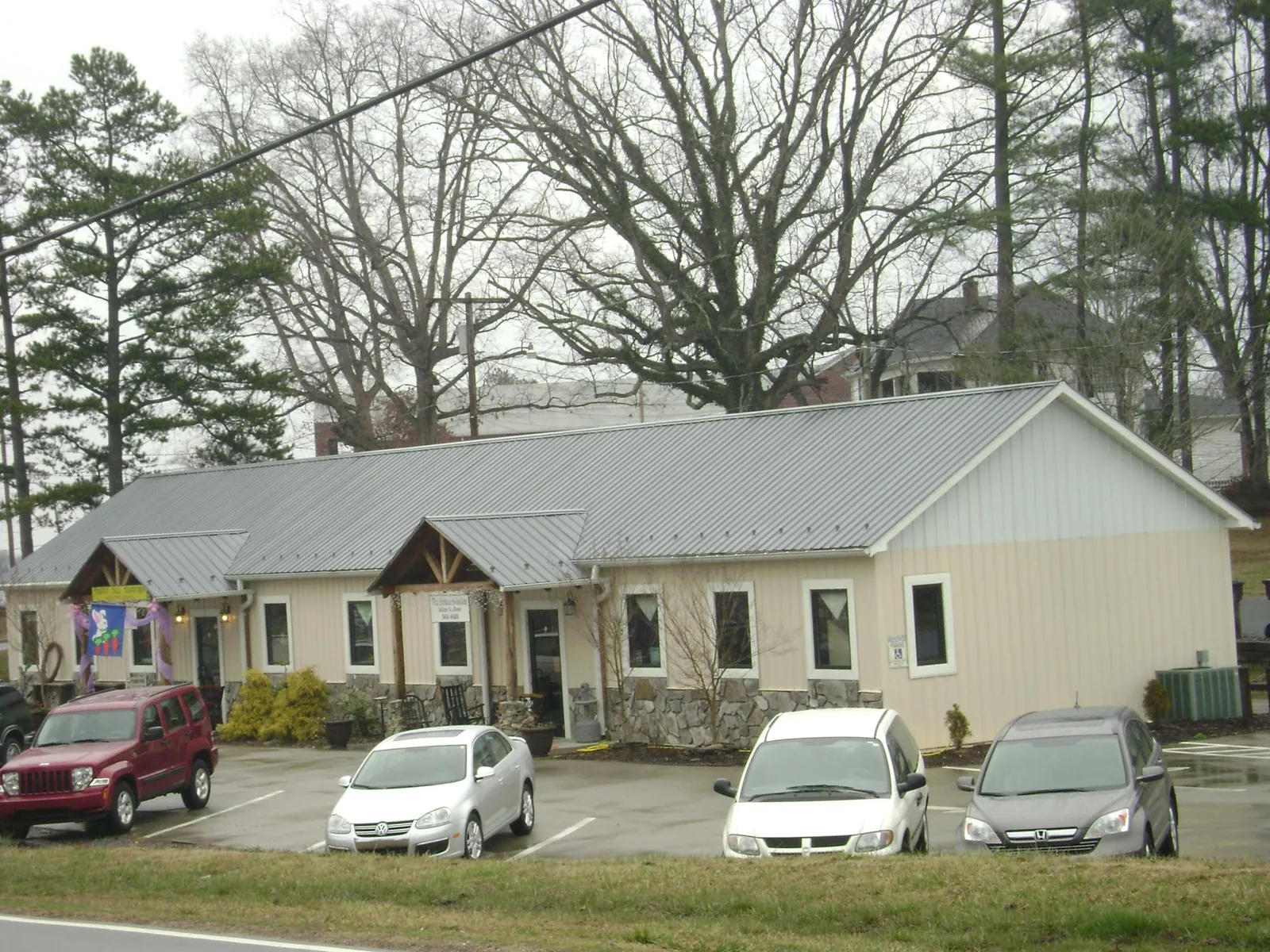 Gray metal roof with timber entry brackets on a small commercial building in Foosland