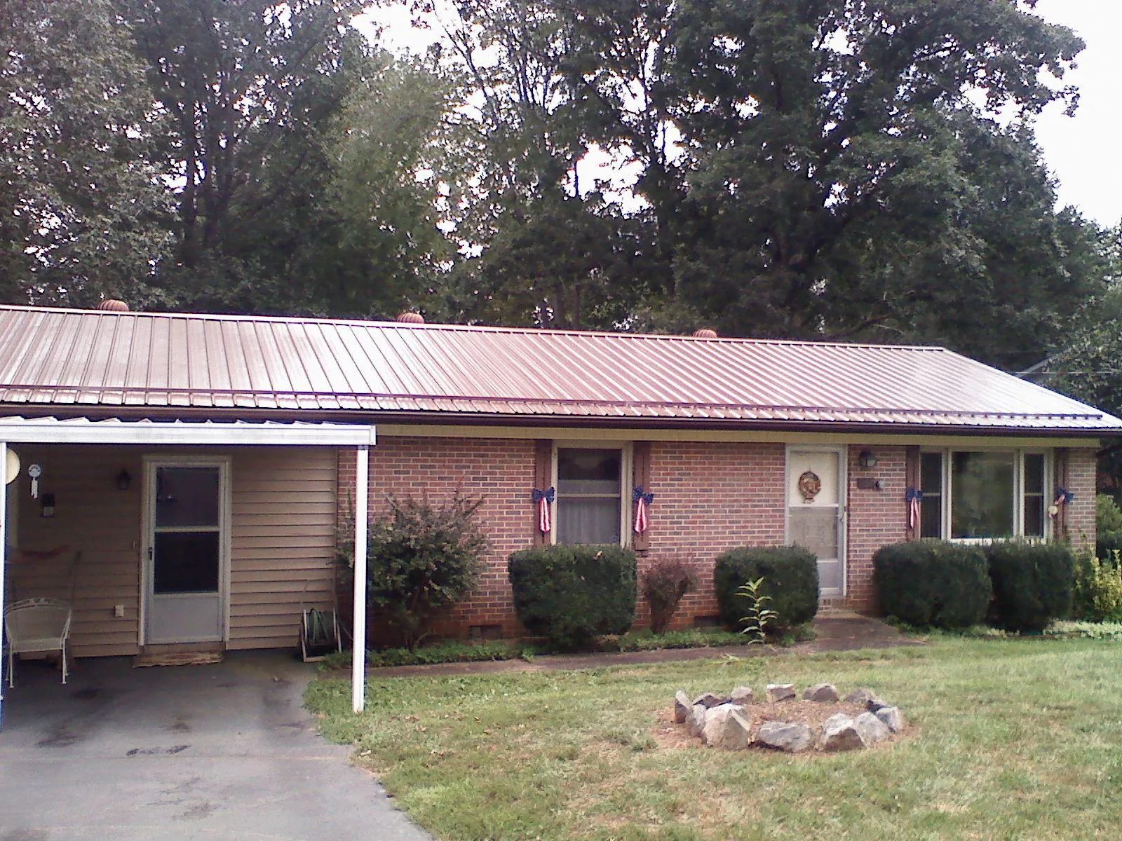 Bronze metal roof and carport on a brick ranch home — Roof Repair work by our crew in Foosland